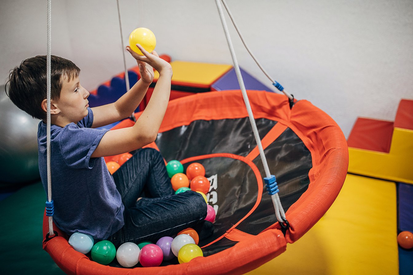 Boy exercising with balls in sensory room